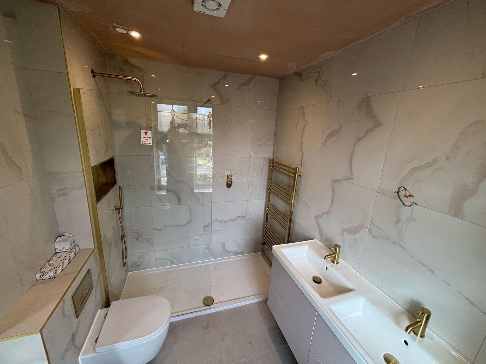Luxury onyx marble bathroom with brushed gold fittings and walk-in shower