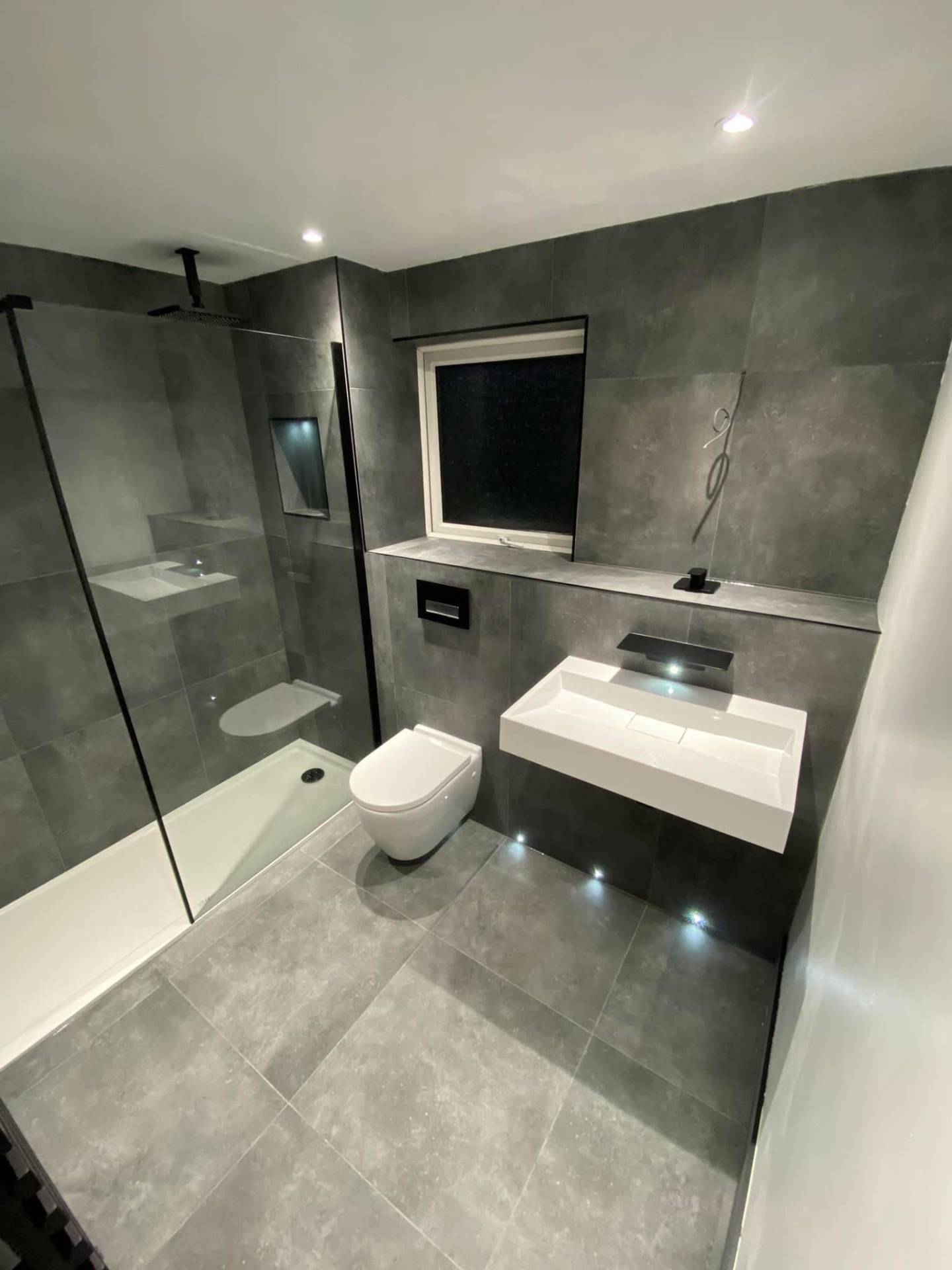 Contemporary grey wetroom with floating vanity and black fixtures