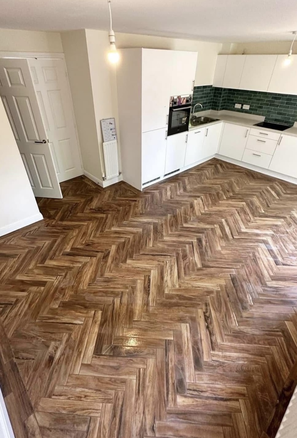 Herringbone wood-effect floor tiling in modern kitchen